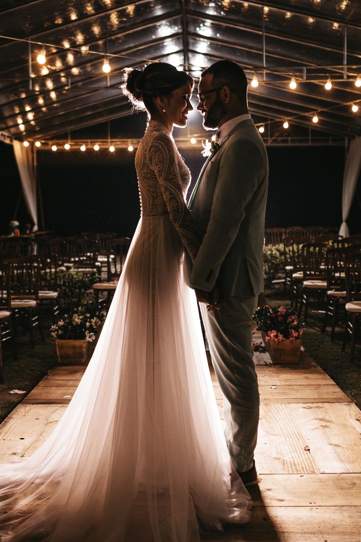 A couple slow-dancing under warm string lights